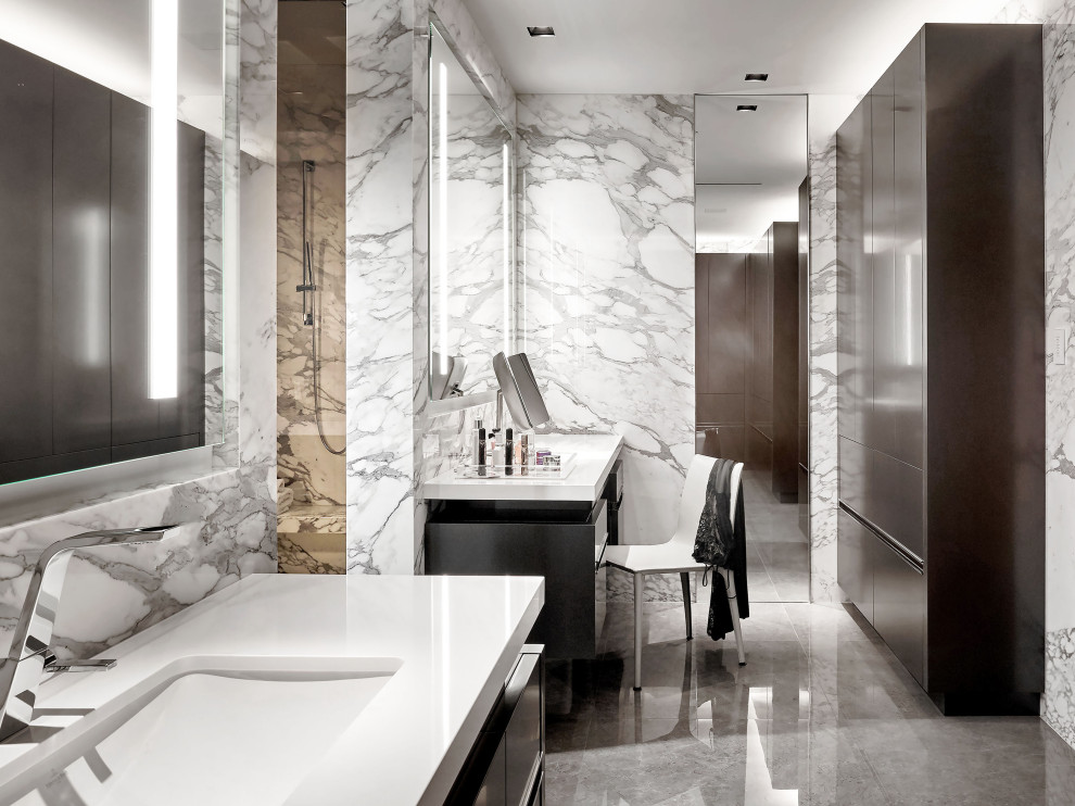Réalisation d'une salle de bain design avec un placard à porte plane, des portes de placard noires, un carrelage gris, des dalles de pierre, un lavabo encastré, un sol gris, un plan de toilette blanc, meuble simple vasque et meuble-lavabo suspendu.