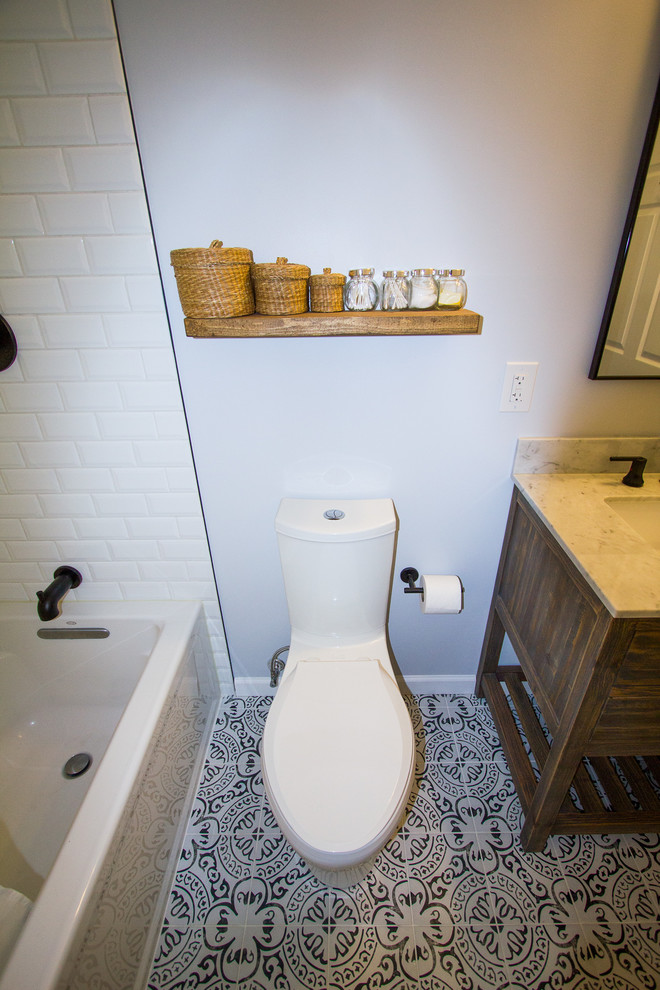 Exempel på ett litet lantligt vit vitt badrum med dusch, med möbel-liknande, skåp i mellenmörkt trä, ett platsbyggt badkar, en dusch/badkar-kombination, en toalettstol med separat cisternkåpa, vit kakel, tunnelbanekakel, blå väggar, klinkergolv i porslin, ett integrerad handfat, bänkskiva i kvartsit, flerfärgat golv och dusch med duschdraperi
