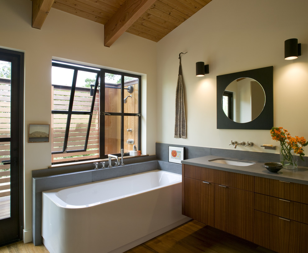 Inredning av ett klassiskt stort en-suite badrum, med släta luckor, skåp i mörkt trä, ett hörnbadkar, grå kakel, stenkakel, beige väggar, mellanmörkt trägolv och ett undermonterad handfat
