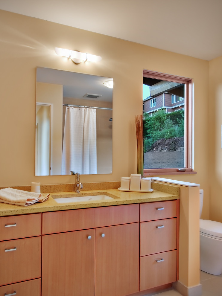 Diseño de cuarto de baño actual con lavabo bajoencimera y ventanas