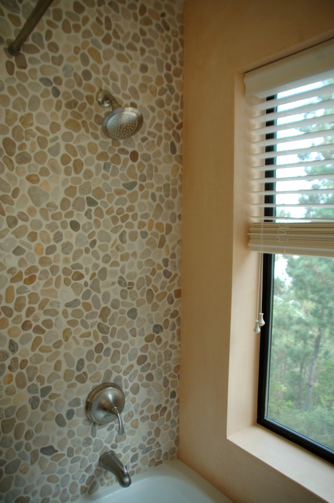 Exempel på ett modernt badrum, med en dusch/badkar-kombination, beige kakel, kakel i småsten och gula väggar