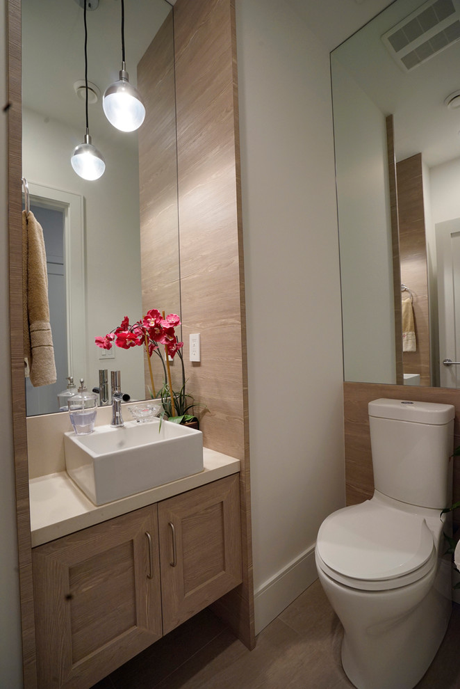 Exempel på ett litet klassiskt badrum, med ett konsol handfat, skåp i ljust trä, laminatbänkskiva, en toalettstol med separat cisternkåpa och stenhäll