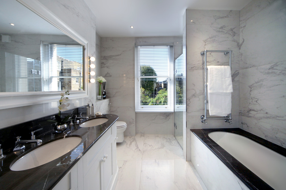 Foto di una stanza da bagno contemporanea di medie dimensioni con ante con riquadro incassato, ante bianche, vasca da incasso, piastrelle bianche, lavabo sottopiano e pavimento bianco