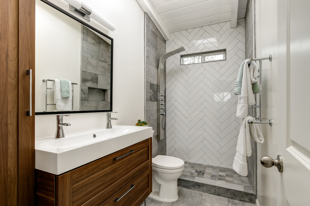 Inspiration för små moderna en-suite badrum, med möbel-liknande, skåp i mellenmörkt trä, en dusch i en alkov, en toalettstol med separat cisternkåpa, vit kakel, tunnelbanekakel, vita väggar, klinkergolv i porslin, ett integrerad handfat och bänkskiva i akrylsten