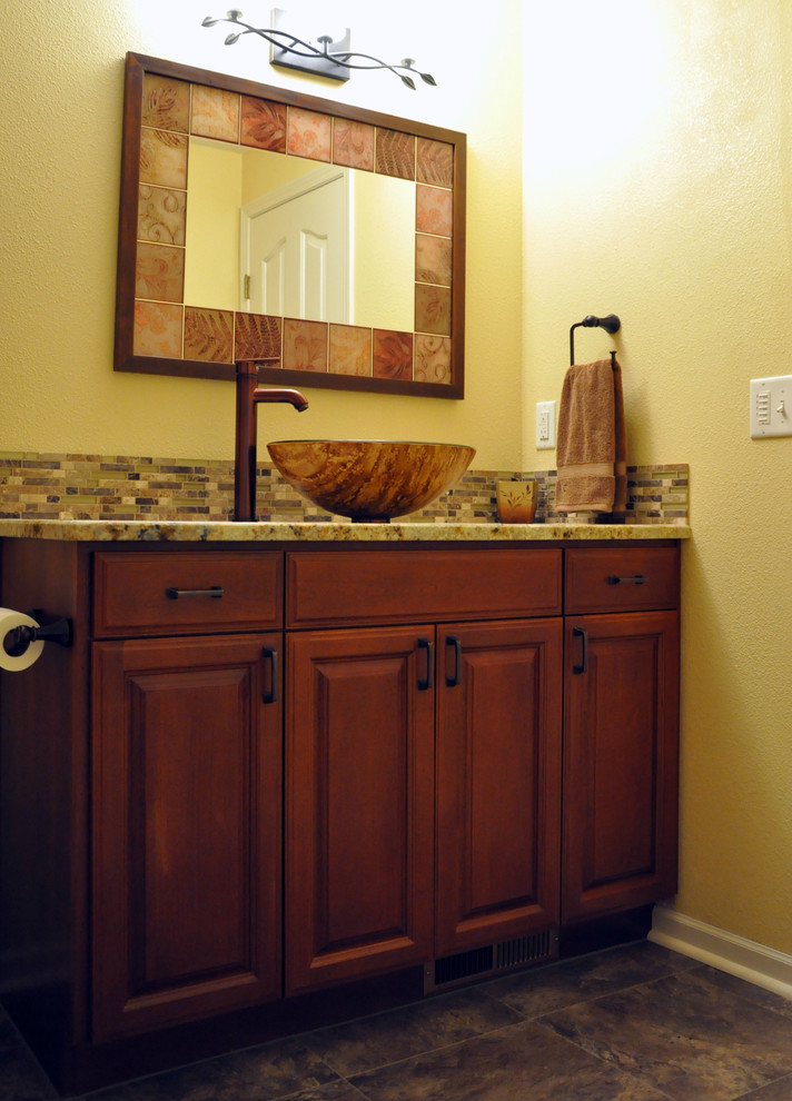 Cette photo montre une salle de bain chic en bois foncé avec une vasque, un plan de toilette en granite, un carrelage multicolore, mosaïque et un mur jaune.