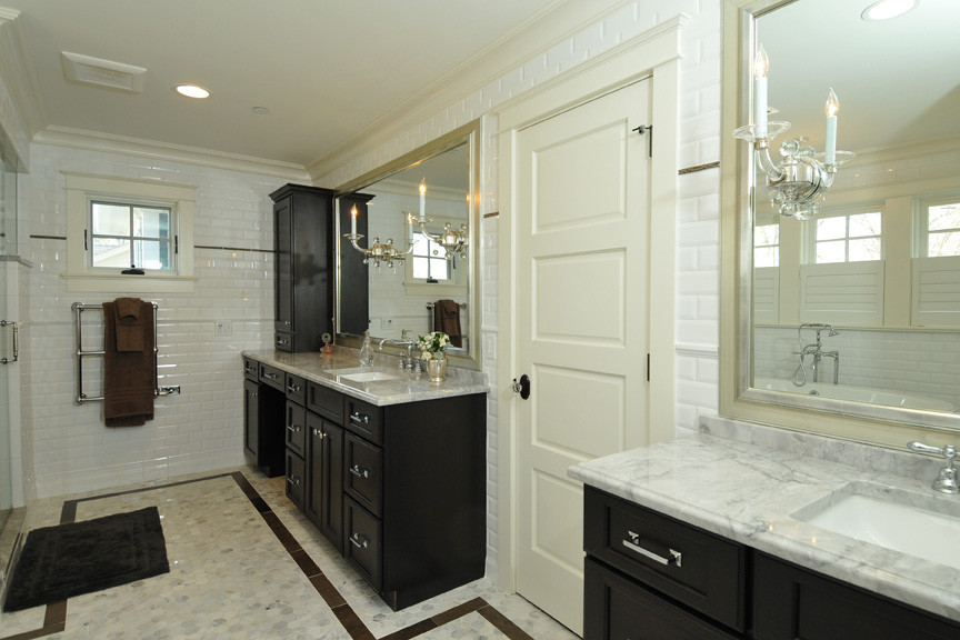Inredning av ett klassiskt stort badrum, med luckor med infälld panel, bruna skåp, marmorbänkskiva, ett fristående badkar, vit kakel, tunnelbanekakel, vita väggar, marmorgolv, ett undermonterad handfat och en dusch i en alkov