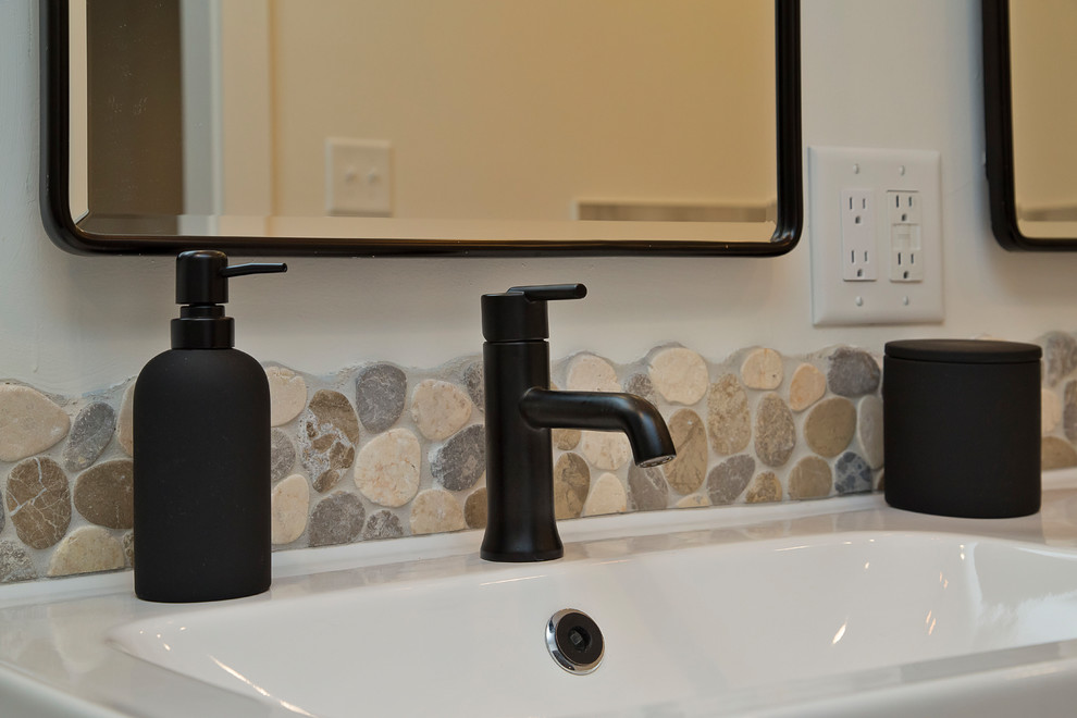 Photo of a medium sized urban ensuite bathroom in Raleigh with flat-panel cabinets, black cabinets, a freestanding bath, a built-in shower, a two-piece toilet, multi-coloured tiles, porcelain tiles, white walls, porcelain flooring, an integrated sink, solid surface worktops, multi-coloured floors, an open shower and white worktops.