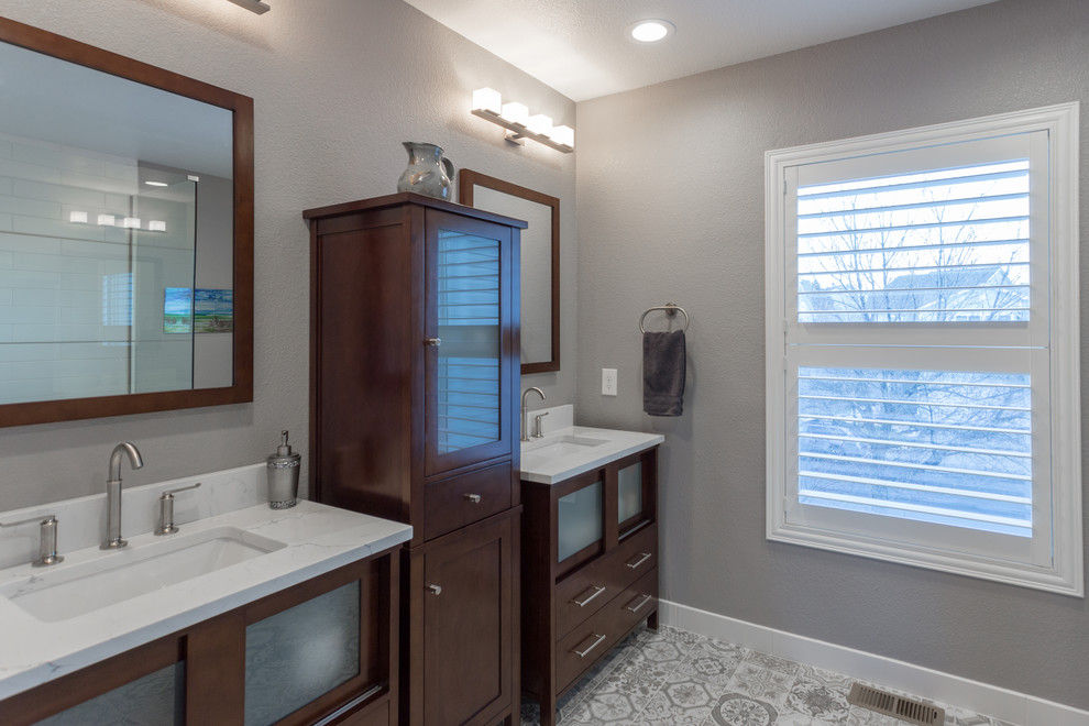 Medium sized contemporary ensuite bathroom in Denver with freestanding cabinets, medium wood cabinets, a corner shower, a two-piece toilet, grey tiles, ceramic tiles, grey walls, ceramic flooring, a submerged sink and engineered stone worktops.