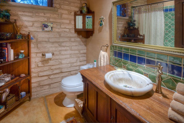 На фото: ванная комната среднего размера в стиле фьюжн с фасадами с утопленной филенкой, темными деревянными фасадами, душем в нише, унитазом-моноблоком, синей плиткой, зеленой плиткой, керамической плиткой, бежевыми стенами, бетонным полом, душевой кабиной, накладной раковиной, столешницей из дерева, коричневым полом и шторкой для ванной