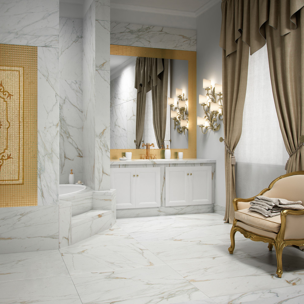 Klassisk inredning av ett stort vit vitt en-suite badrum, med luckor med infälld panel, vita skåp, ett platsbyggt badkar, en toalettstol med separat cisternkåpa, grå kakel, vit kakel, stenhäll, grå väggar, marmorgolv, ett undermonterad handfat, marmorbänkskiva och vitt golv