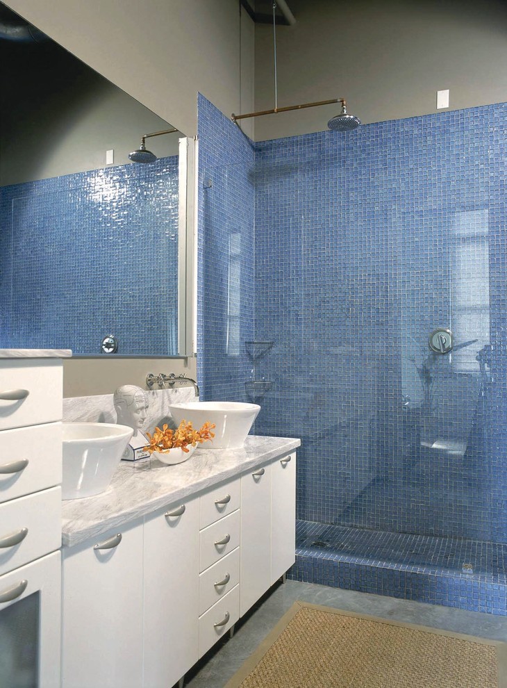 デトロイトにあるトラディショナルスタイルのおしゃれな浴室 (ベッセル式洗面器、フラットパネル扉のキャビネット、白いキャビネット、アルコーブ型シャワー、青いタイル、モザイクタイル、グレーの壁、コンクリートの床、グレーの洗面カウンター) の写真