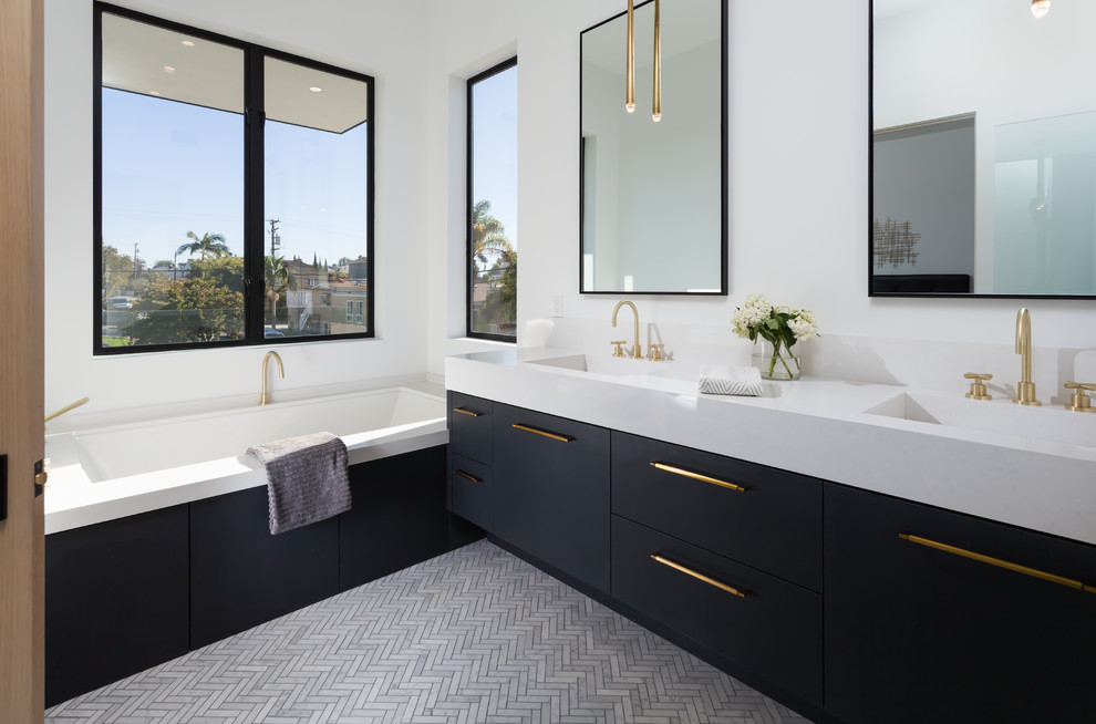 Immagine di una stanza da bagno padronale design con ante lisce, ante nere, vasca sottopiano, pareti bianche, lavabo integrato e pavimento grigio