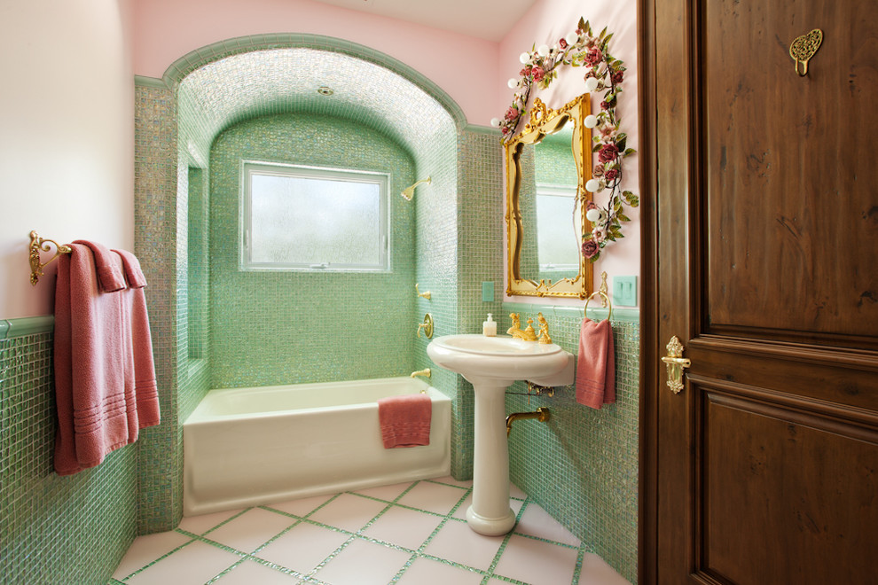 Mediterranean bathroom in San Luis Obispo with a pedestal sink, an alcove bath, a shower/bath combination, green tiles, glass tiles, pink walls and ceramic flooring.