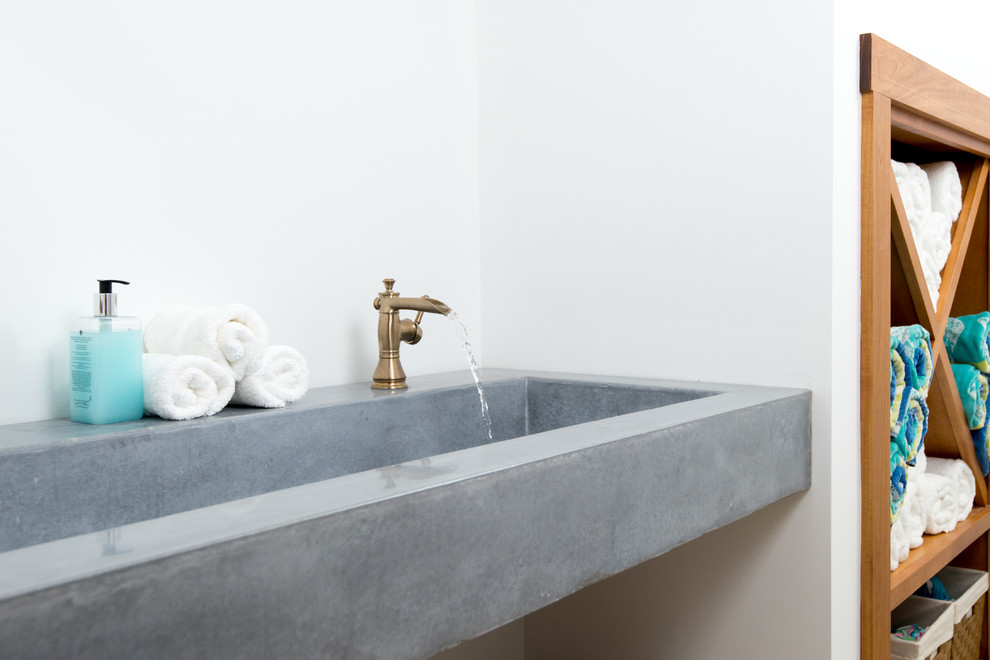 Modelo de cuarto de baño contemporáneo con paredes blancas, lavabo integrado, encimera de cemento y encimeras grises