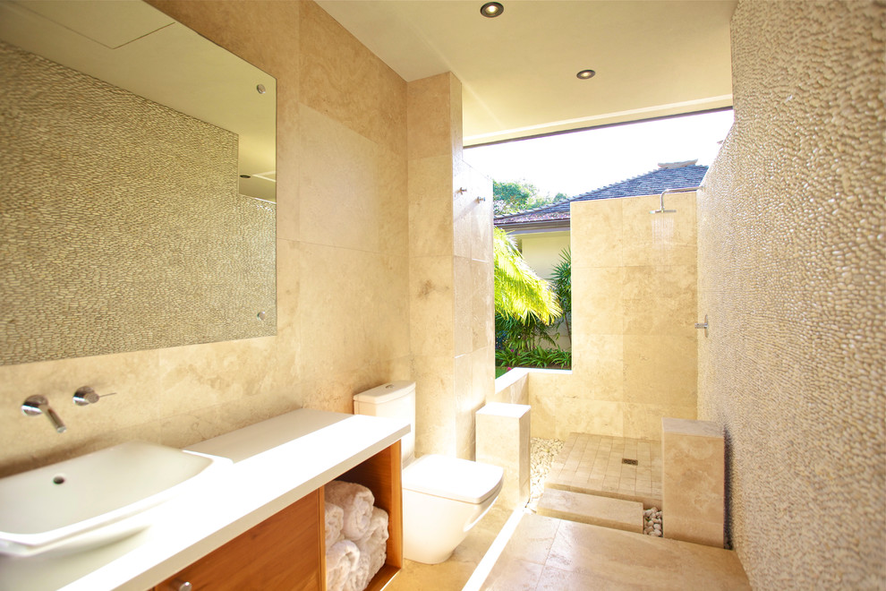 Cette image montre une salle de bain design avec une douche ouverte, une vasque, aucune cabine et un mur en pierre.