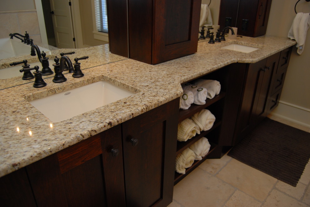 Esempio di una stanza da bagno design con lavabo sottopiano, ante in stile shaker, ante in legno bruno, top in granito e vasca da incasso