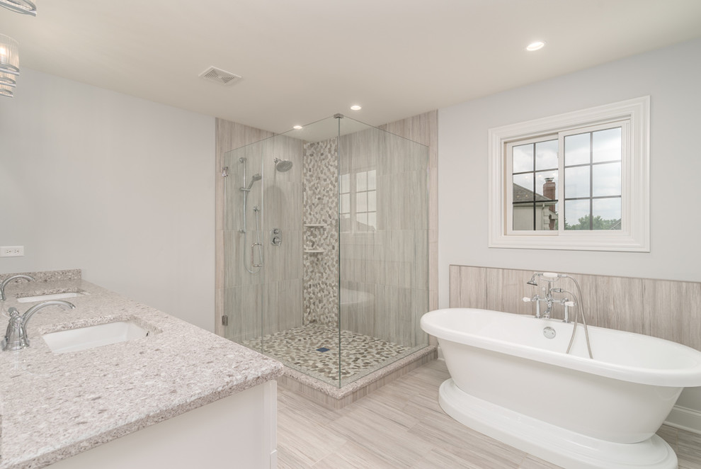 Пример оригинального дизайна: главная ванная комната среднего размера в стиле неоклассика (современная классика) с белыми фасадами, отдельно стоящей ванной, угловым душем, бежевой плиткой, коричневой плиткой, серой плиткой, белой плиткой, керамогранитной плиткой, серыми стенами, полом из керамогранита, врезной раковиной, бежевым полом, душем с распашными дверями, фасадами с утопленной филенкой, раздельным унитазом, столешницей терраццо и серой столешницей