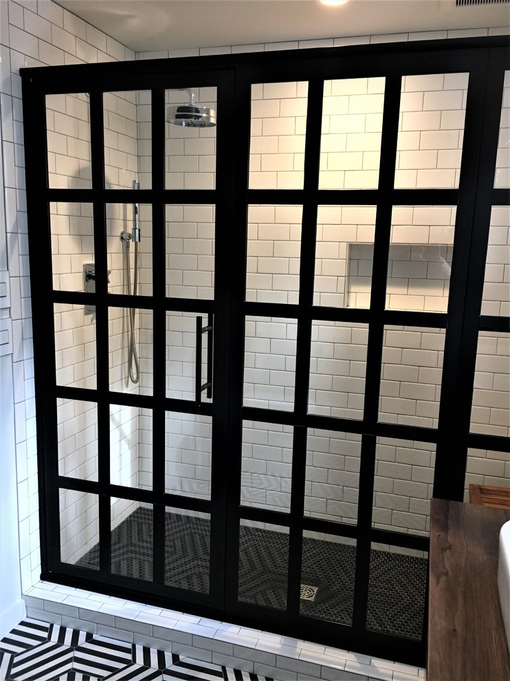 Alcove shower - mid-sized mid-century modern master white tile and subway tile multicolored floor alcove shower idea in Other with flat-panel cabinets, dark wood cabinets, white walls, a vessel sink, wood countertops, a hinged shower door and brown countertops