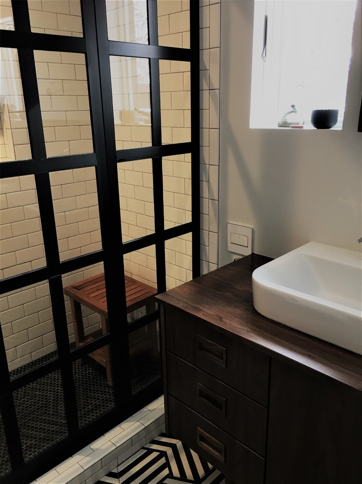Mid-sized 1950s master white tile and subway tile multicolored floor alcove shower photo in Other with flat-panel cabinets, dark wood cabinets, white walls, a vessel sink, wood countertops, a hinged shower door and brown countertops
