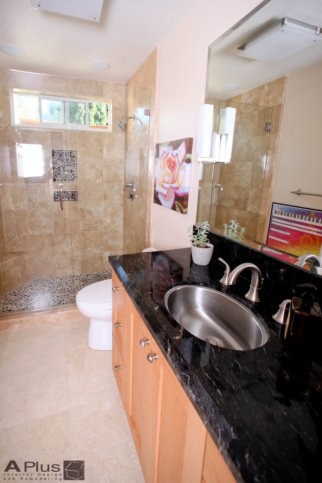 This is an example of a medium sized contemporary ensuite bathroom in Orange County with a built-in sink, shaker cabinets, light wood cabinets, granite worktops, a walk-in shower, a two-piece toilet, beige tiles, porcelain tiles, beige walls and porcelain flooring.