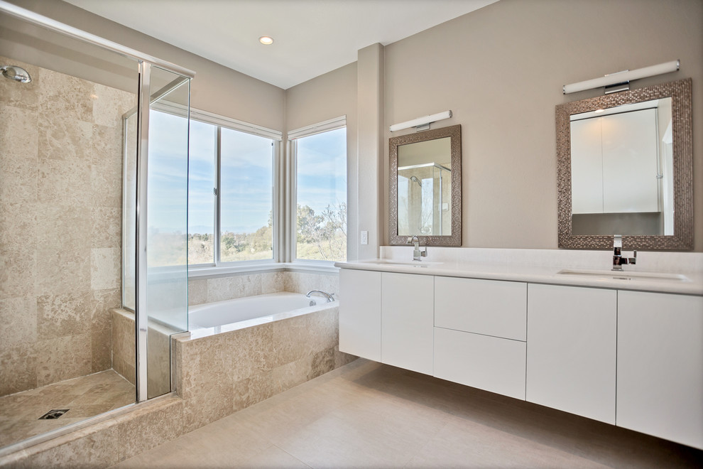 Exempel på ett mellanstort modernt en-suite badrum, med släta luckor, vita skåp, en kantlös dusch, vit kakel, beiget golv och dusch med gångjärnsdörr