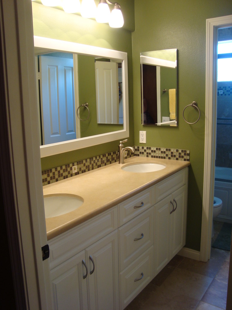 This is an example of a small classic family bathroom in Orange County with a submerged sink, raised-panel cabinets, white cabinets, engineered stone worktops, an alcove bath, an alcove shower, a two-piece toilet, beige tiles, porcelain tiles, green walls and porcelain flooring.