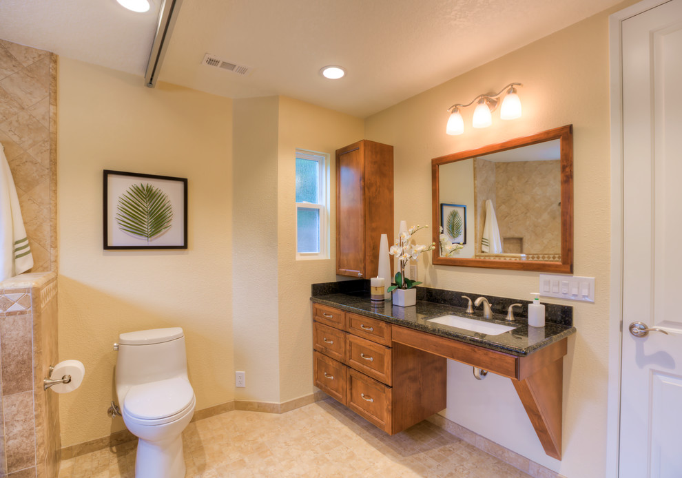 Example of a mid-sized classic 3/4 beige tile and porcelain tile porcelain tile alcove shower design in Orange County with an undermount sink, shaker cabinets, medium tone wood cabinets, granite countertops, a two-piece toilet and beige walls