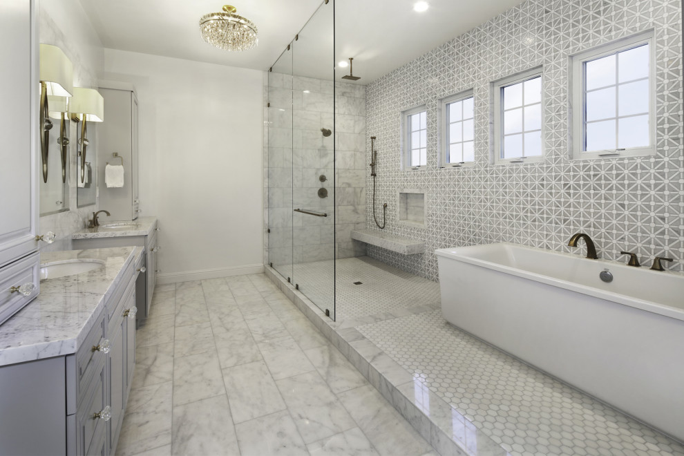 Cette photo montre une salle de bain principale tendance de taille moyenne avec un placard avec porte à panneau surélevé, des portes de placard grises, une baignoire indépendante, un espace douche bain, un carrelage gris et une cabine de douche à porte battante.