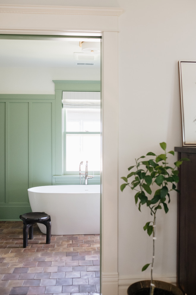 Cette image montre une salle de bain principale craftsman en bois foncé avec une baignoire indépendante, un carrelage blanc, des carreaux de céramique, un mur vert, tomettes au sol, un lavabo encastré, un plan de toilette en marbre, un sol multicolore et un plan de toilette blanc.