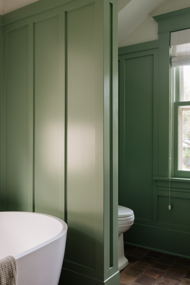 На фото: главная ванная комната в стиле кантри с темными деревянными фасадами, отдельно стоящей ванной, белой плиткой, керамической плиткой, зелеными стенами, полом из терракотовой плитки, врезной раковиной, мраморной столешницей, разноцветным полом и белой столешницей