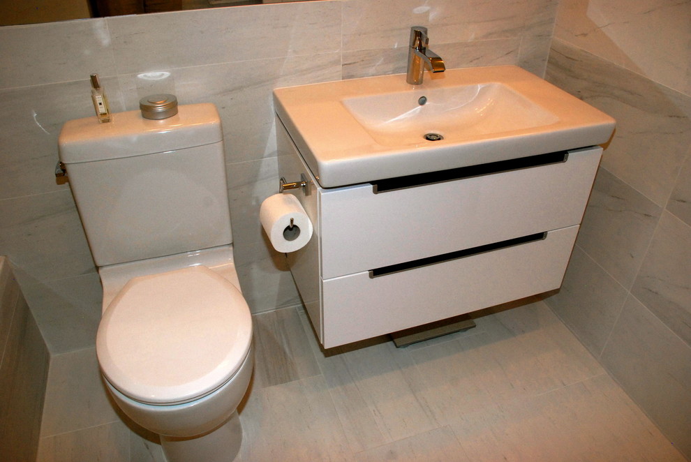 Modernes Badezimmer mit flächenbündigen Schrankfronten, weißen Schränken und Toilette mit Aufsatzspülkasten in New York