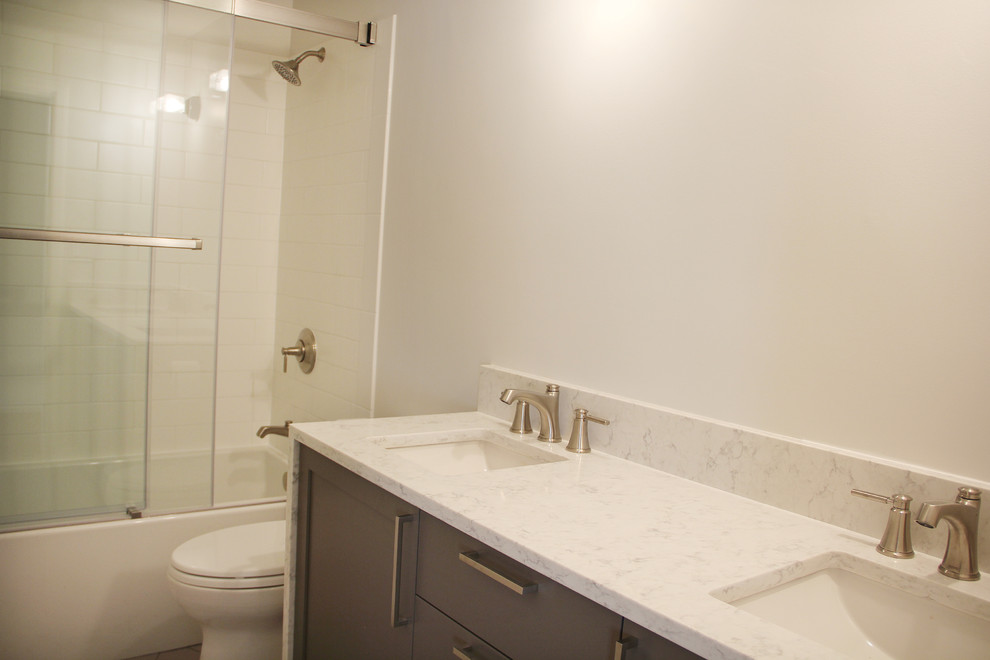 Mid-sized minimalist 3/4 white tile and subway tile bathroom photo in Portland with shaker cabinets, gray cabinets, white walls, an undermount sink and quartz countertops