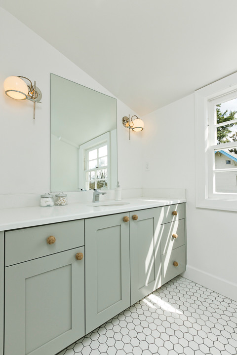 Mittelgroßes Duschbad mit integriertem Waschbecken, Schrankfronten mit vertiefter Füllung, grünen Schränken, Mineralwerkstoff-Waschtisch, weißen Fliesen, Keramikfliesen, weißer Wandfarbe und Keramikboden in Portland
