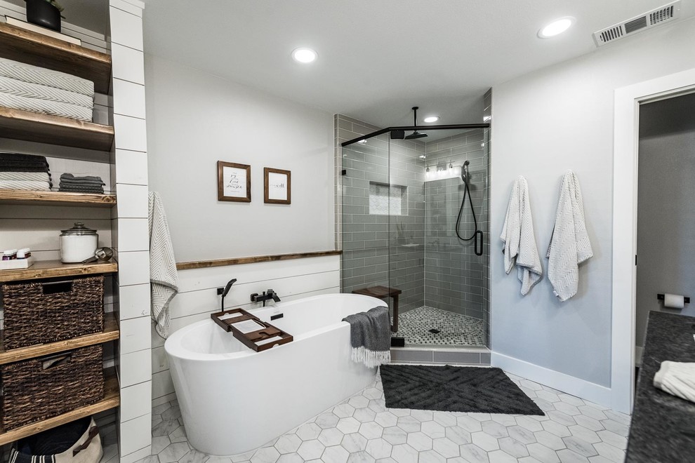 Inspiration for a large farmhouse master gray tile and ceramic tile ceramic tile and gray floor bathroom remodel in Dallas with shaker cabinets, white cabinets, a one-piece toilet, gray walls, an undermount sink, granite countertops, a hinged shower door and black countertops