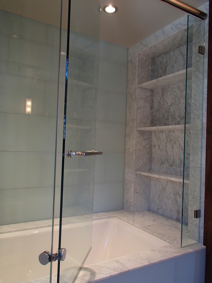 На фото: ванная комната в стиле неоклассика (современная классика) с врезной раковиной, мраморной столешницей, полновстраиваемой ванной, душем над ванной, унитазом-моноблоком, зеленой плиткой, стеклянной плиткой и серыми стенами
