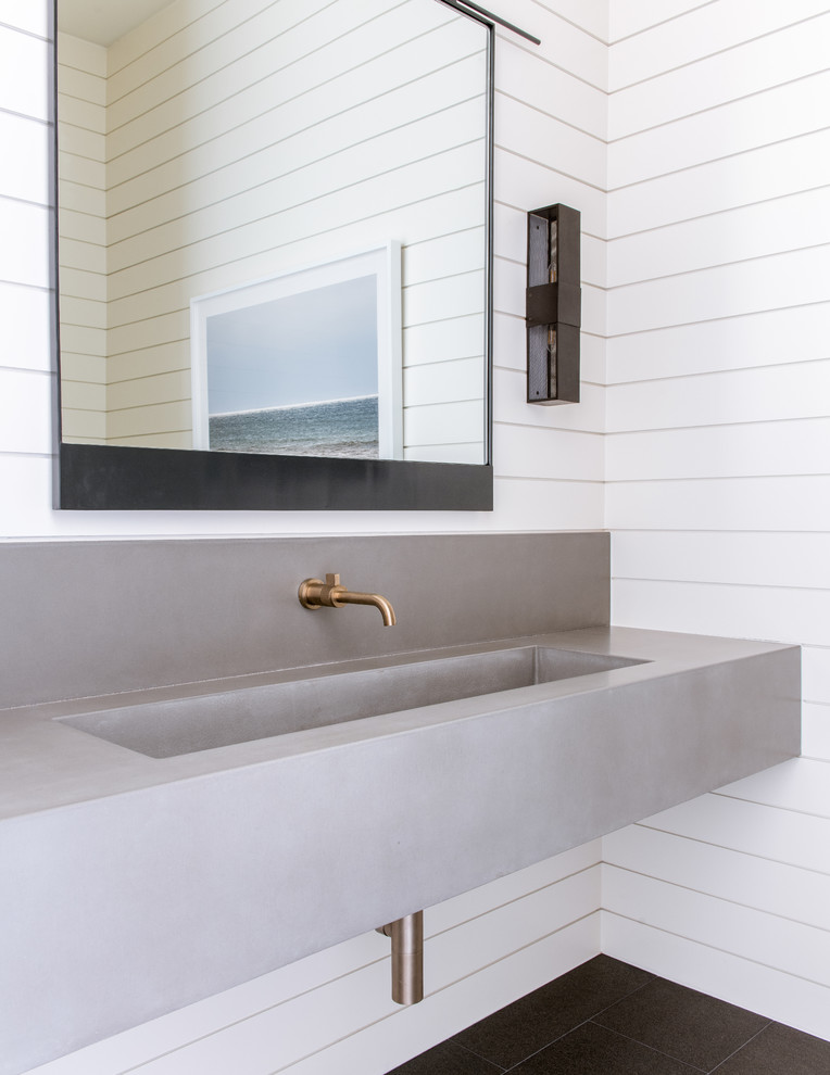 Modelo de cuarto de baño mediterráneo grande con paredes blancas, suelo de baldosas de porcelana, lavabo integrado, encimera de cemento, suelo negro, encimeras grises y espejo con luz