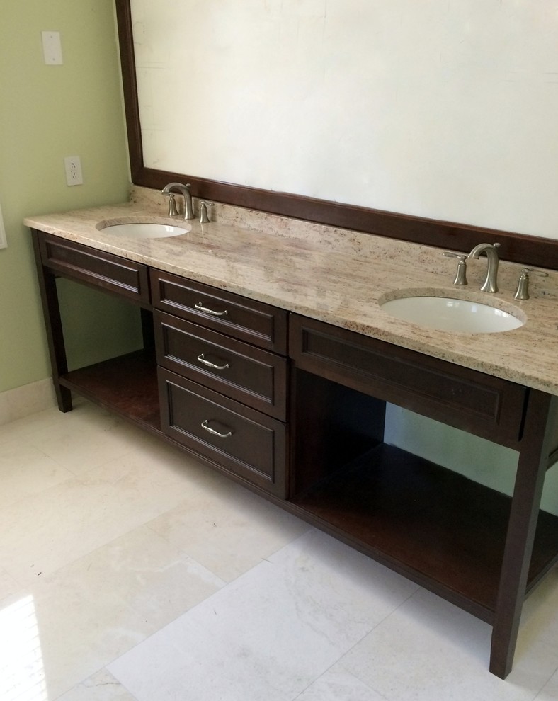 Photo of a large world-inspired ensuite bathroom in Tampa with granite worktops, green walls, travertine flooring, beige tiles, beaded cabinets, dark wood cabinets and a submerged sink.