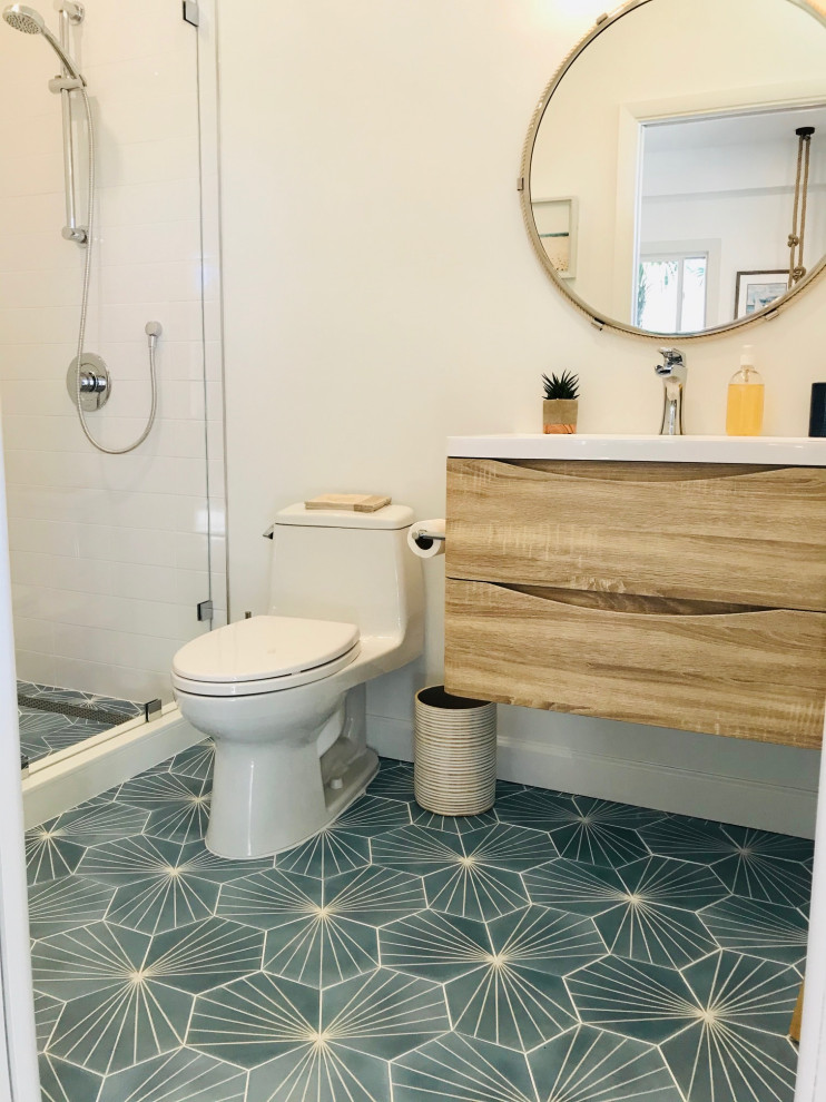 Пример оригинального дизайна: главная ванная комната в морском стиле с плоскими фасадами, светлыми деревянными фасадами, открытым душем, унитазом-моноблоком, белой плиткой, керамической плиткой, белыми стенами, полом из цементной плитки, монолитной раковиной, столешницей из ламината, синим полом, открытым душем, желтой столешницей, тумбой под одну раковину и подвесной тумбой