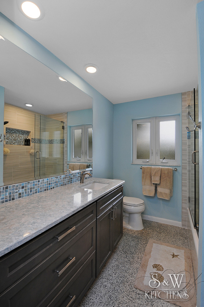 Exemple d'une petite salle de bain principale bord de mer avec un placard avec porte à panneau encastré, des portes de placard grises, une baignoire en alcôve, un combiné douche/baignoire, WC séparés, un carrelage bleu, des carreaux de porcelaine, un mur bleu, un lavabo encastré et un plan de toilette en quartz modifié.