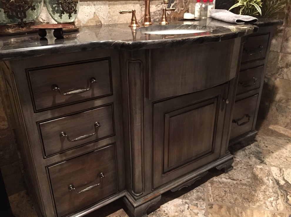 This is an example of a small rustic bathroom in Austin with a submerged sink, raised-panel cabinets, distressed cabinets, granite worktops, beige tiles, stone tiles, beige walls and travertine flooring.