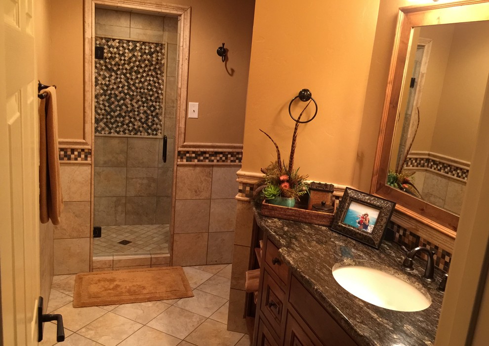 This is an example of a small rustic family bathroom in Austin with a submerged sink, raised-panel cabinets, distressed cabinets, granite worktops, an alcove shower, beige tiles, stone tiles, beige walls and travertine flooring.