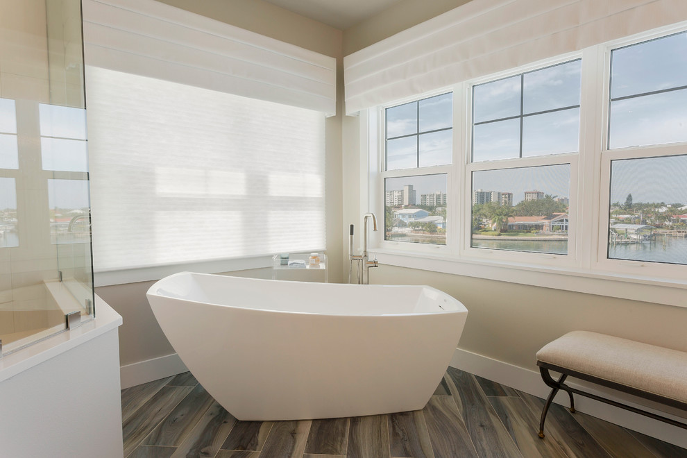 Mittelgroßes Klassisches Badezimmer mit freistehender Badewanne, offener Dusche, dunklem Holzboden, grauem Boden, Falttür-Duschabtrennung, grauer Wandfarbe und Duschbank in Tampa