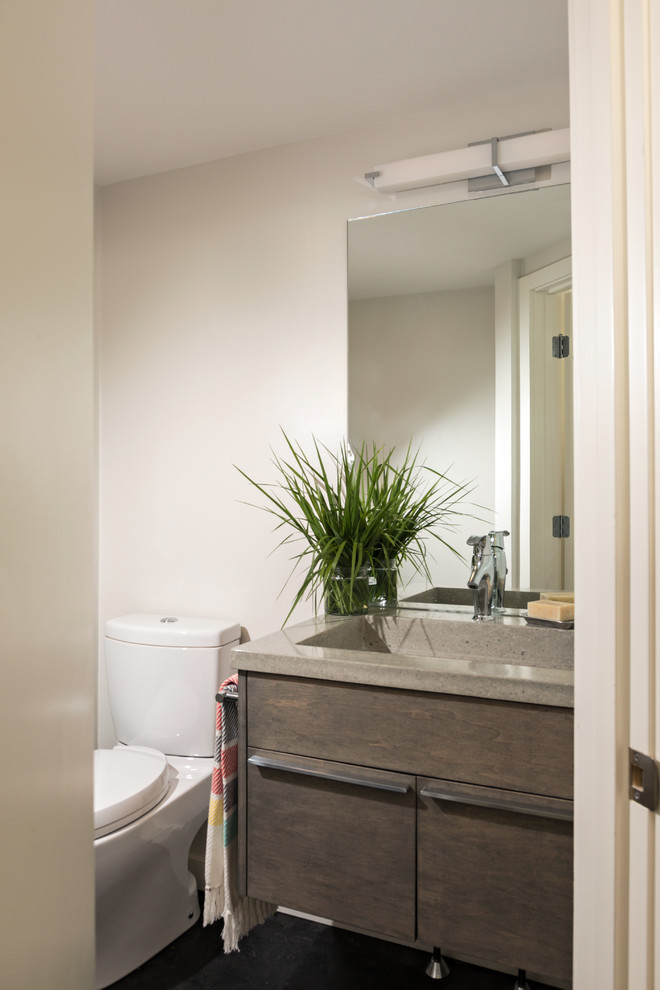Imagen de cuarto de baño costero con armarios con paneles lisos, puertas de armario de madera oscura, paredes blancas, encimera de cemento y lavabo de seno grande