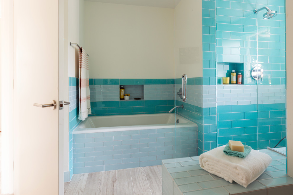 Inspiration pour une douche en alcôve marine en bois foncé avec une baignoire en alcôve, un carrelage bleu, un carrelage en pâte de verre, un mur blanc, parquet clair, un placard à porte plane et un plan de toilette en bois.