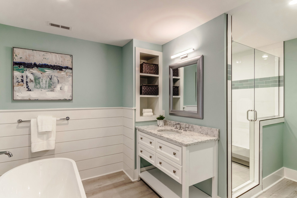 Diseño de cuarto de baño principal costero de tamaño medio con armarios estilo shaker, puertas de armario blancas, lavabo bajoencimera, encimera de mármol y encimeras blancas