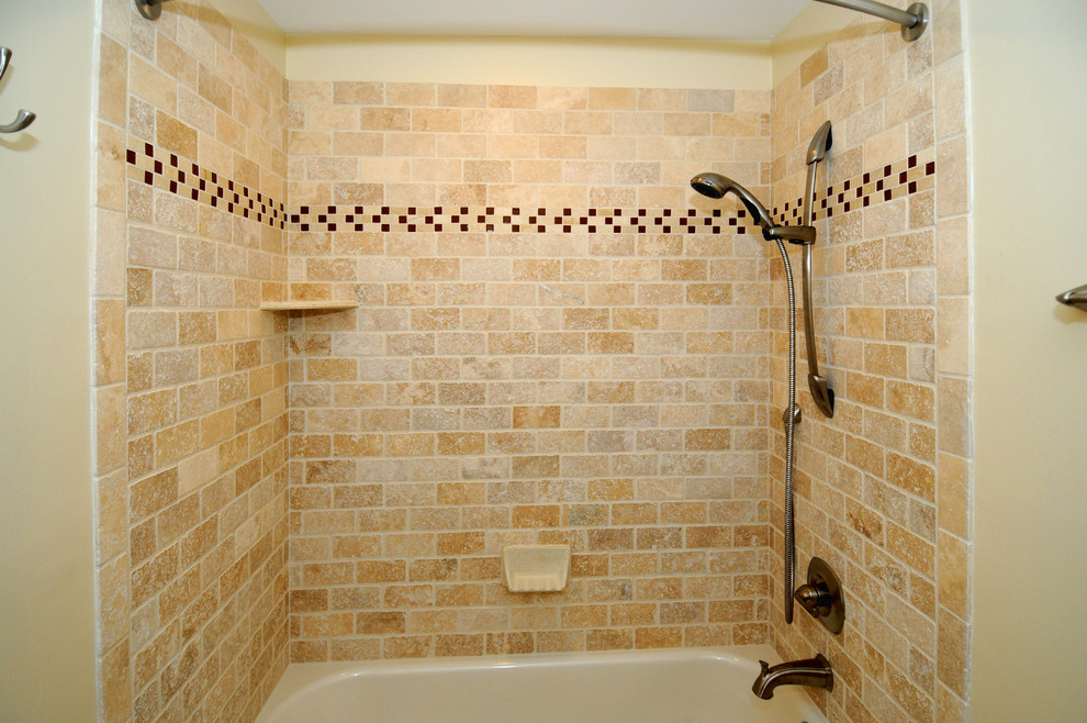 マイアミにあるトラディショナルスタイルのおしゃれな浴室 (アルコーブ型浴槽、シャワー付き浴槽	、ベージュのタイル、マルチカラーのタイル、オレンジのタイル、黄色いタイル、石タイル、ベージュの壁) の写真