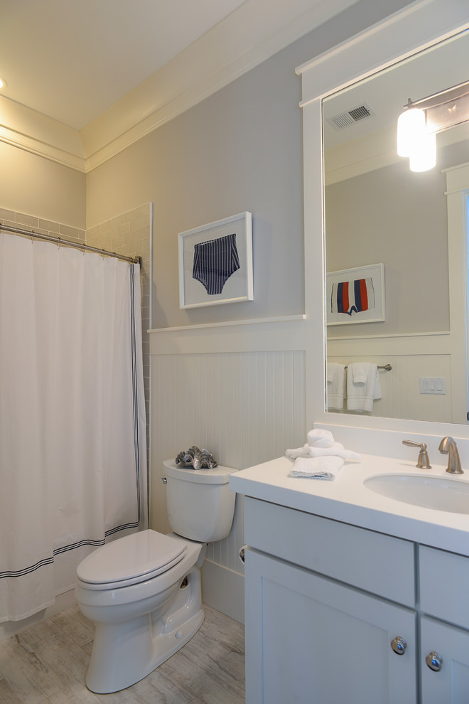 Idéer för mellanstora maritima badrum med dusch, med skåp i shakerstil, gula skåp, ett badkar i en alkov, en dusch/badkar-kombination, en toalettstol med separat cisternkåpa, grå kakel, tunnelbanekakel, grå väggar, klinkergolv i porslin, ett undermonterad handfat, laminatbänkskiva, beiget golv och dusch med duschdraperi