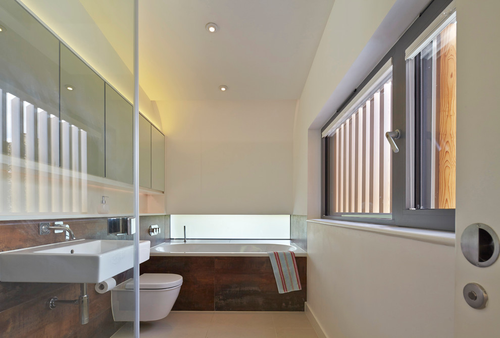 Photo of a contemporary ensuite bathroom in London with medium wood cabinets.