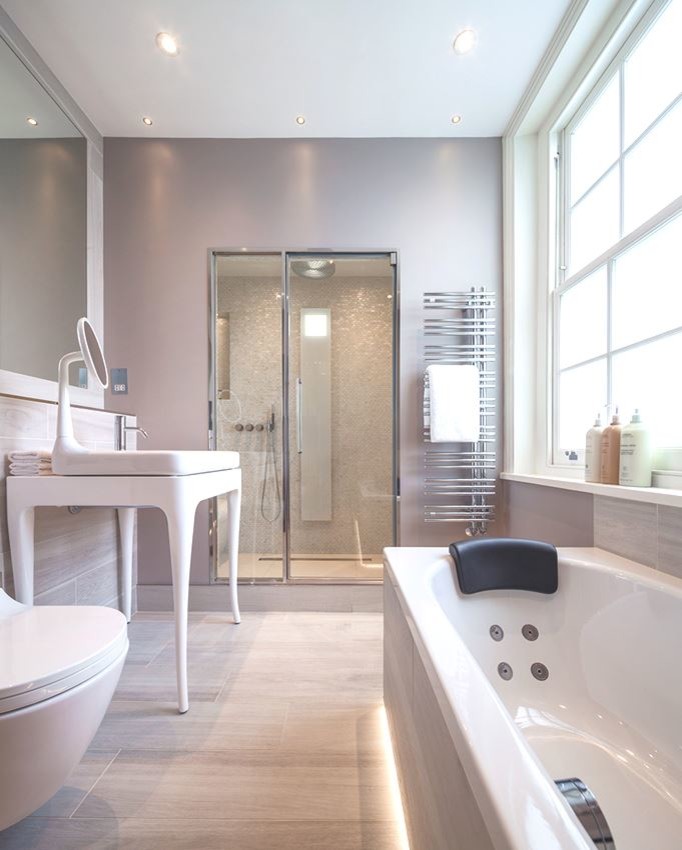 Design ideas for a medium sized contemporary family bathroom in London with a vessel sink, freestanding cabinets, a built-in bath, an alcove shower, a wall mounted toilet, beige tiles, porcelain tiles, beige walls, porcelain flooring and white cabinets.