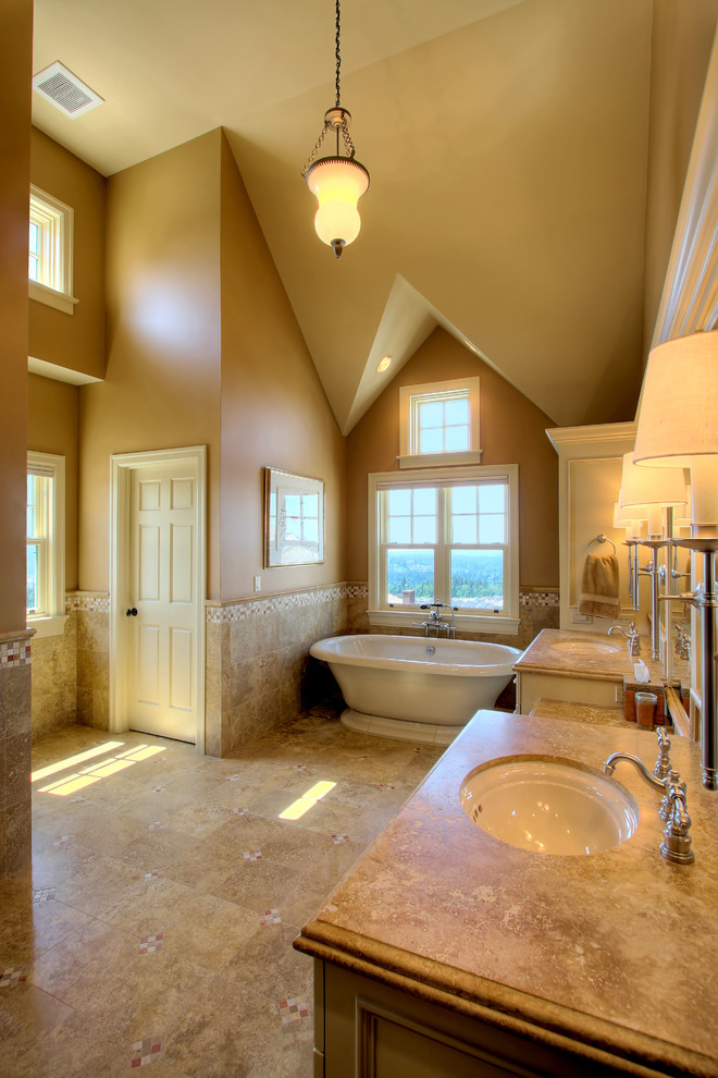 This is an example of a classic bathroom in Seattle with a freestanding bath and travertine tiles.